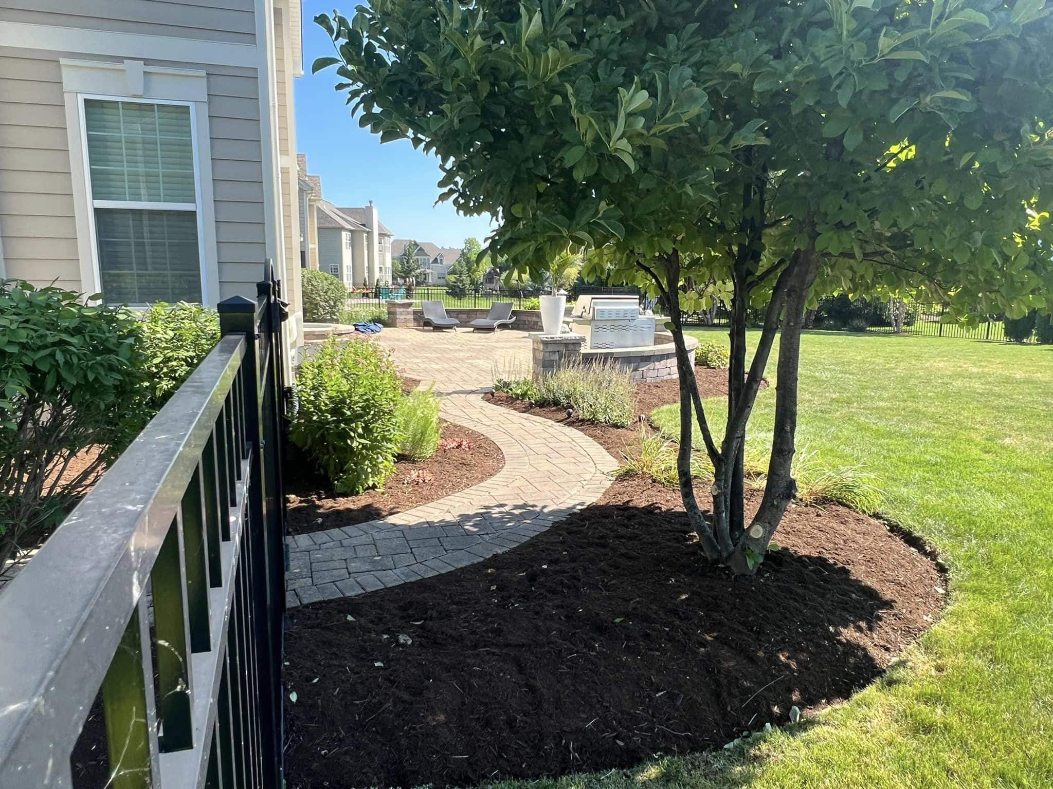 Newly built hardscape in the backyard, surrounded by fresh mulch, expertly designed and installed by Arellano Landscaping for a beautiful outdoor space.
