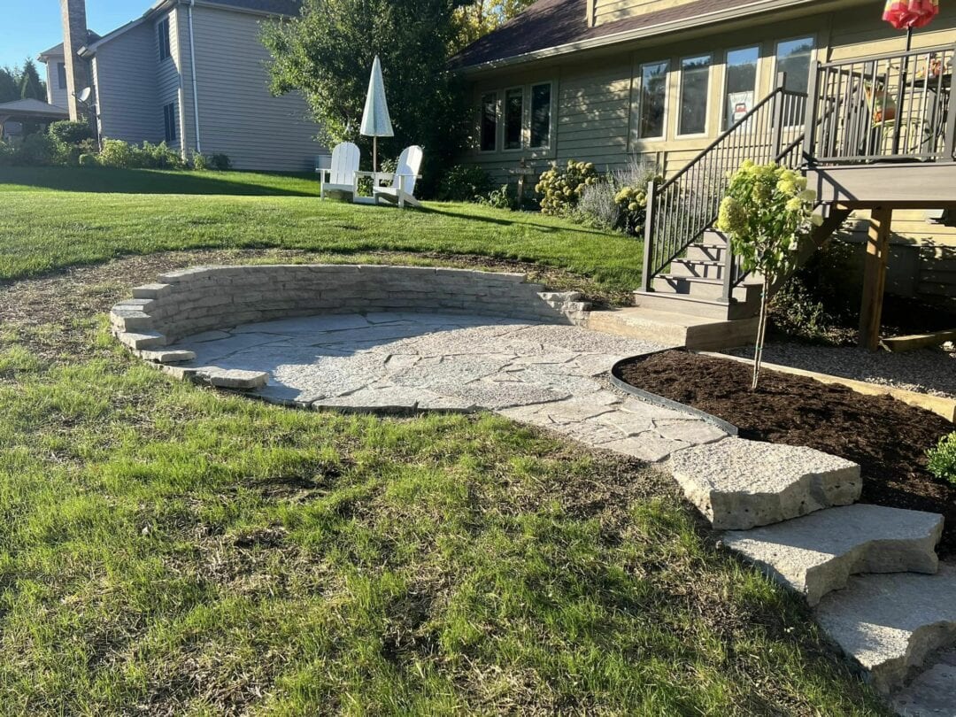 Circular hardscape retaining wall in front of a house, expertly designed and installed by Arellano Landscaping for a stylish and functional outdoor space.