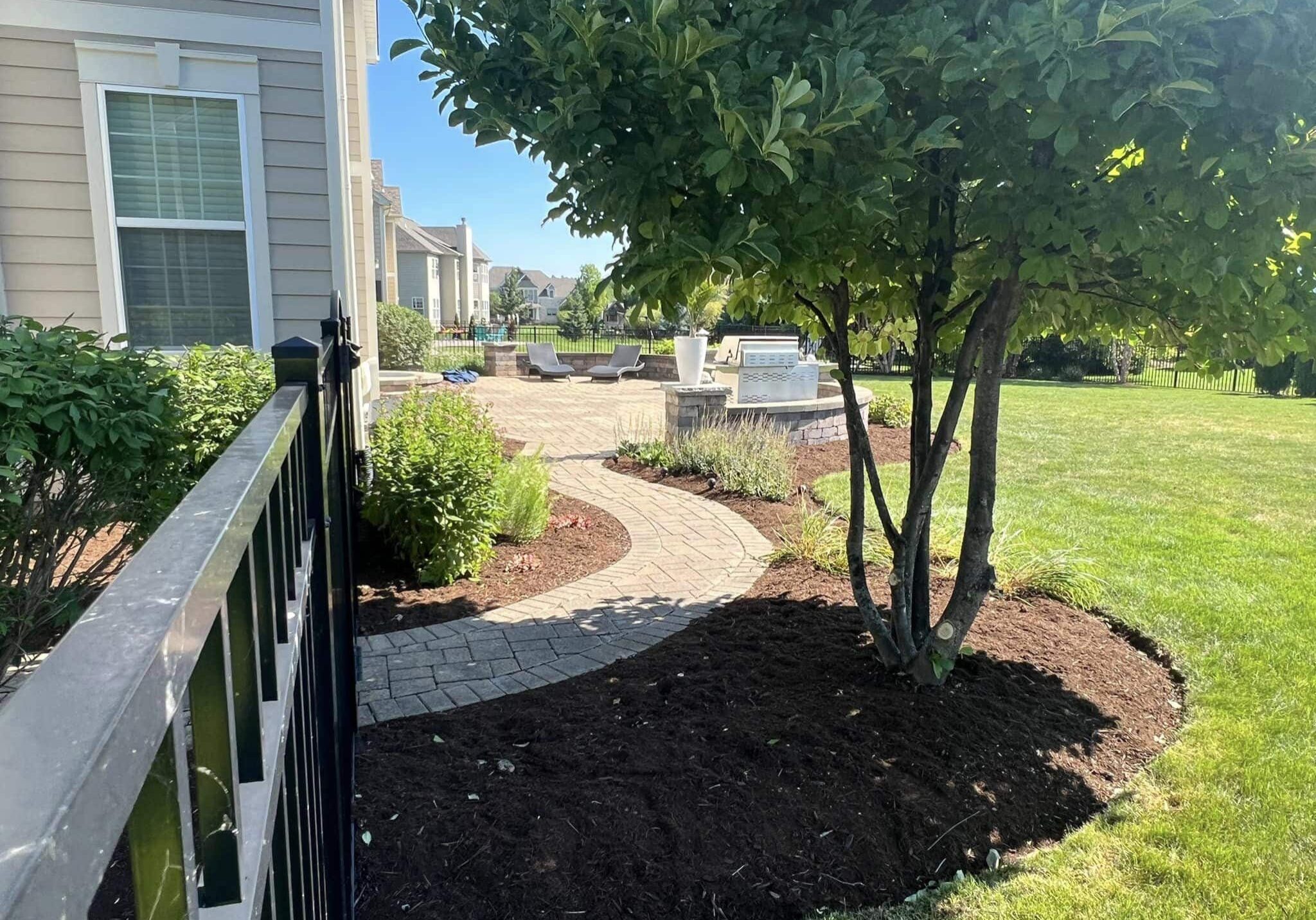 Newly built hardscape in the backyard, surrounded by fresh mulch, expertly designed and installed by Arellano Landscaping for a beautiful outdoor space.