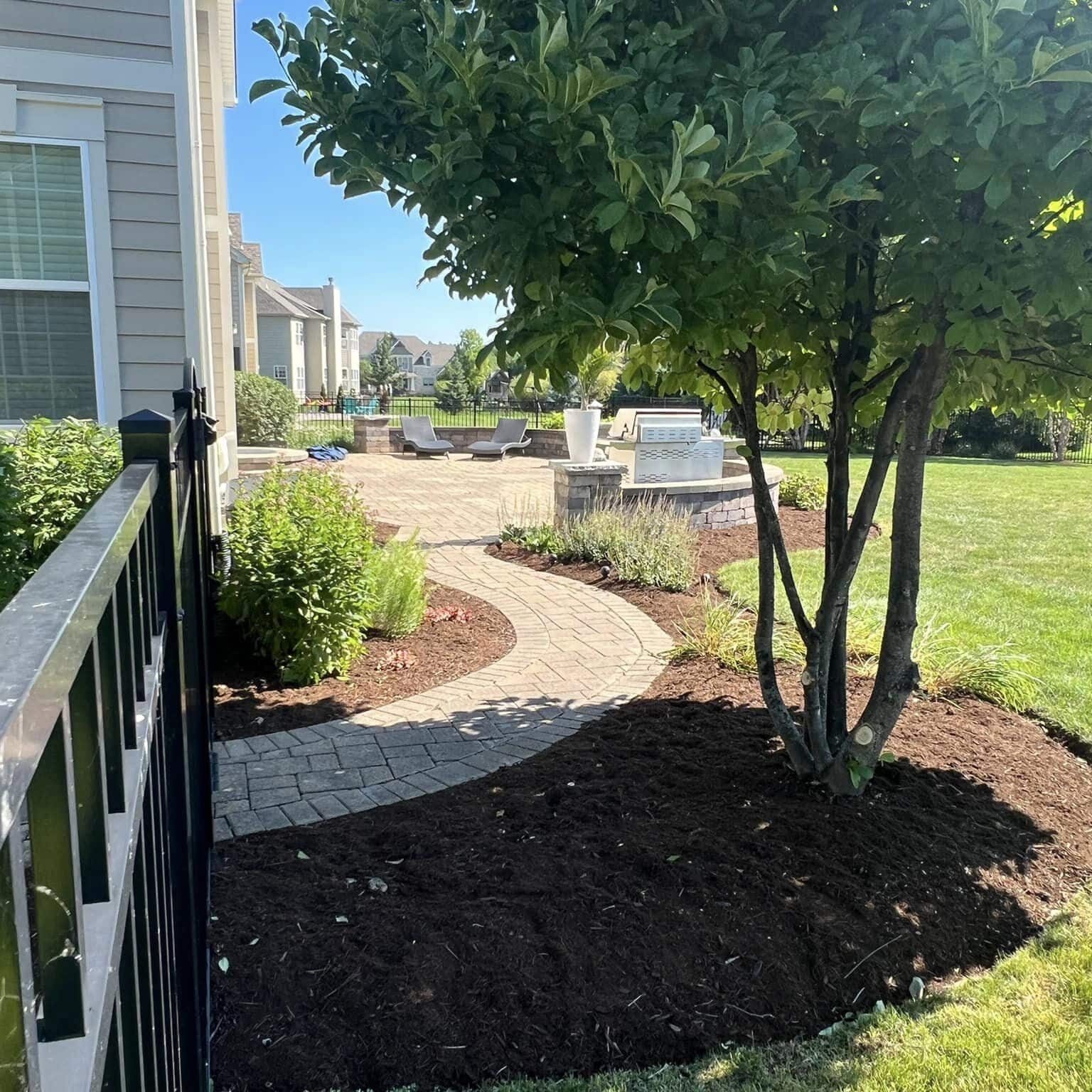 Newly built hardscape in the backyard, surrounded by fresh mulch, expertly designed and installed by Arellano Landscaping for a beautiful outdoor space.