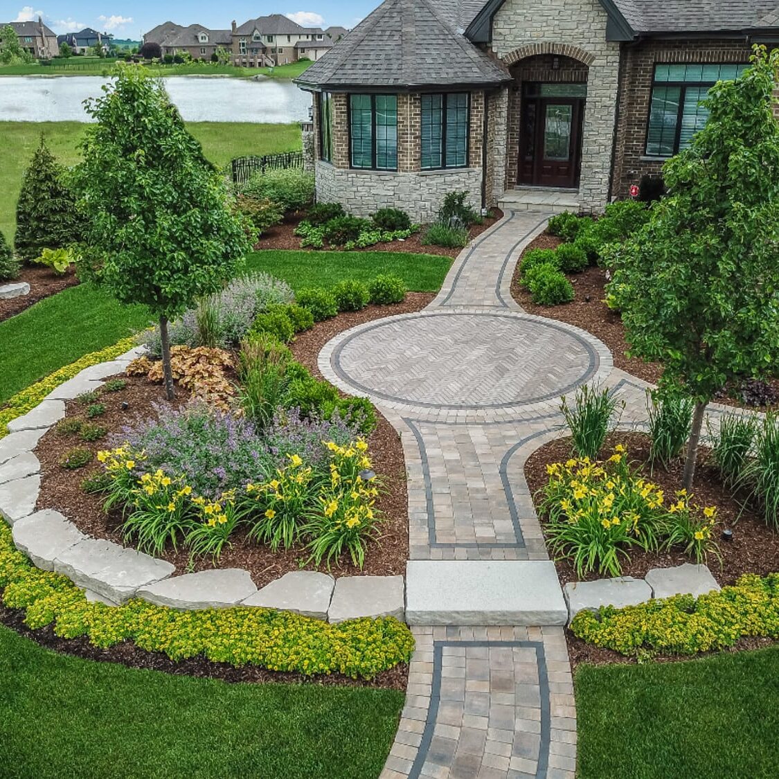 Newly completed front yard landscaping with fresh plantings and mulch in St. Charles IL by Arellano Landscaping