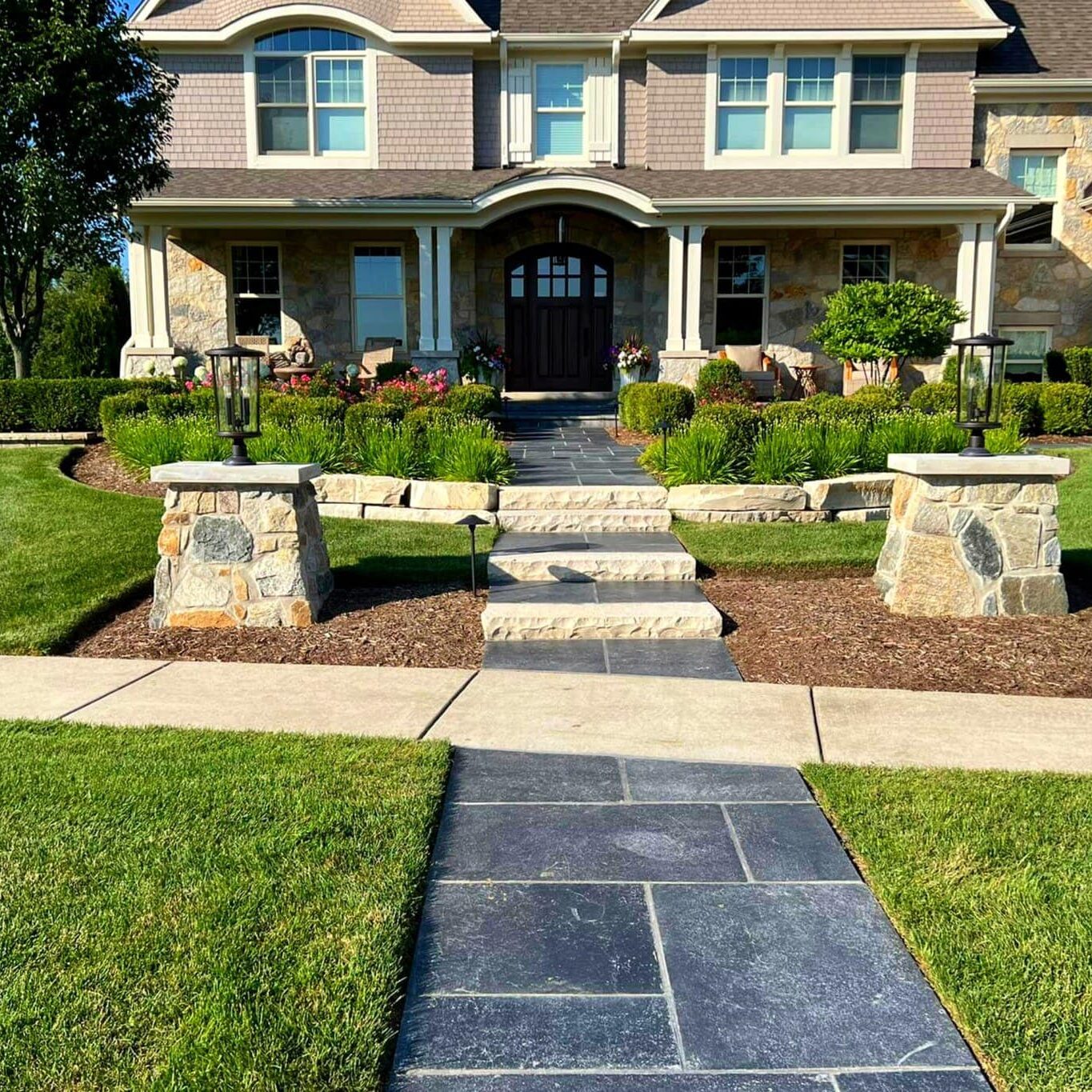 Beautifully landscaped front yard with a retaining wall, designed and installed by Arellano Landscaping, enhancing curb appeal with expert craftsmanship